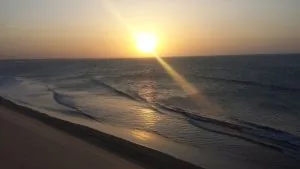 Turistas reunidos no topo da Duna do Pôr do Sol para assistir ao entardecer no mar em Jericoacoara