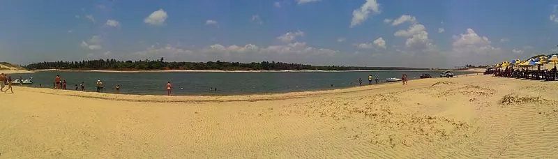 Panorama da Lagoa do Uruaú, em Beberibe, com banhistas na margem, guarda-sóis e areia clara