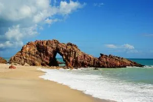 Monumento natural da Pedra Furada na praia de Jericoacoara durante a maré baixa