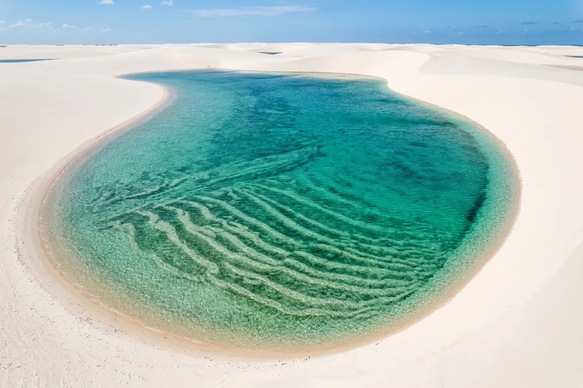 Lagoa de água doce e cristalina formada pela chuva entre as dunas